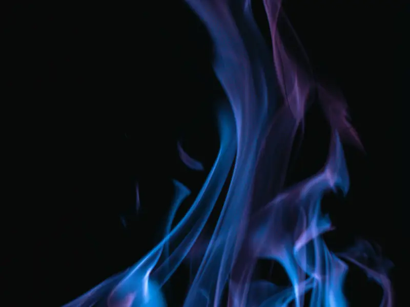 Blue gas flame against a dark background