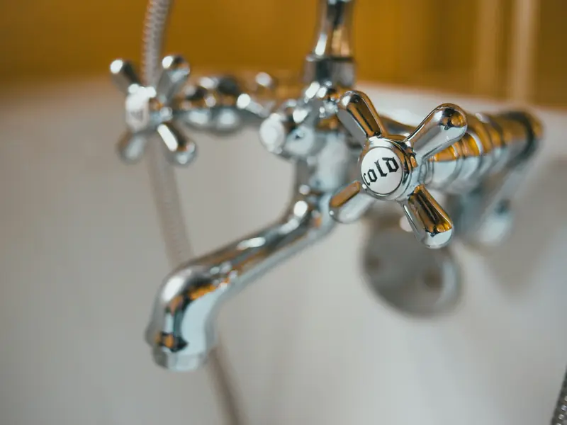 A chrome tub faucet with cross handles