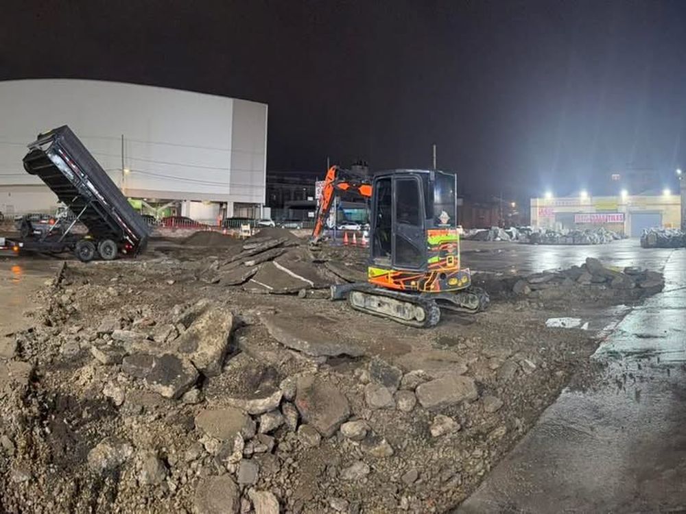 Excavator and dump truck on a cleared residential lot