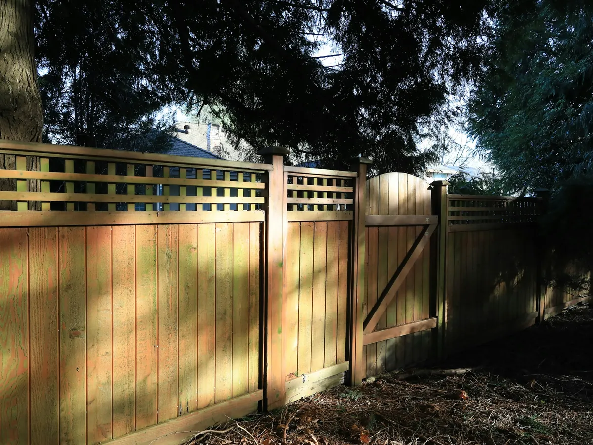 A cedar privacy fence with a lattice top and a matching walk gate