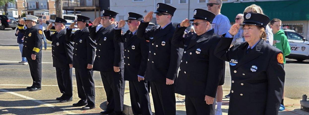 CHFC firefighters standing in dress uniform in salute